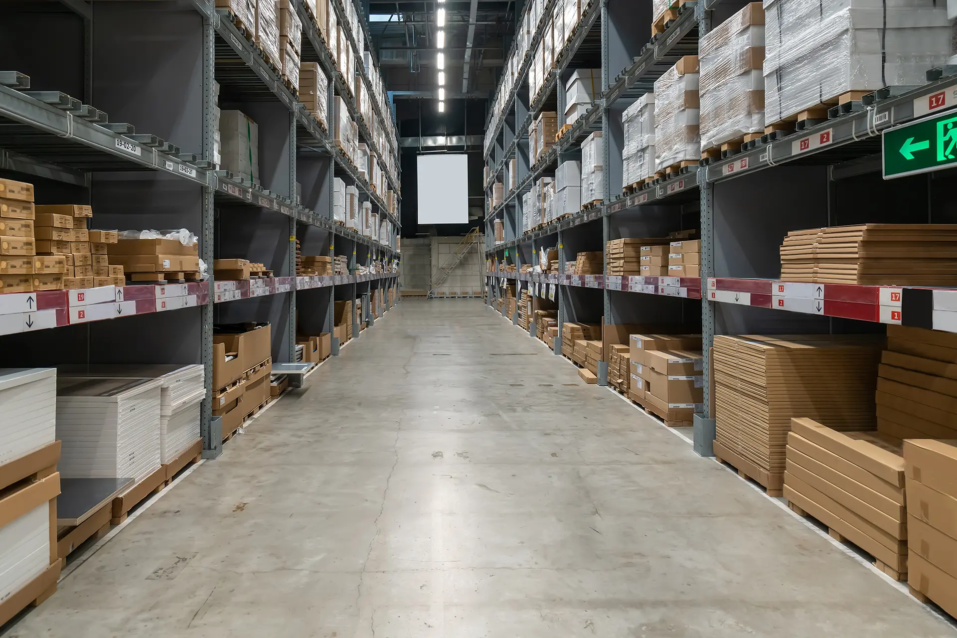 Corsia di un magazzino industriale con scaffalature alte, ideale per l’uso di generatori a gasolio indiretti per il riscaldamento dei capannoni