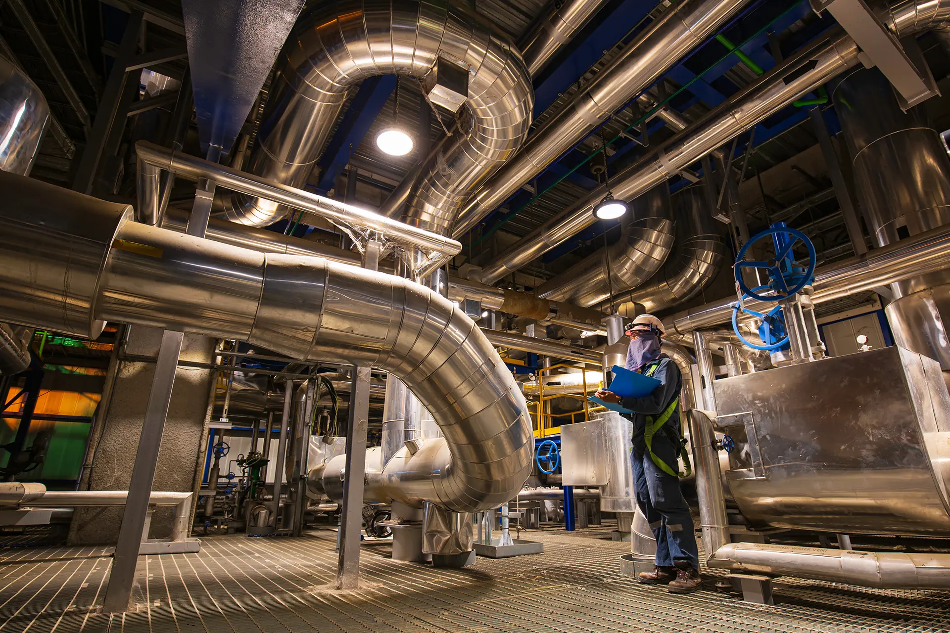 Pompa di calore industriale installata in impianto produttivo con tecnico specializzato, simbolo di come funzionano le pompe di calore industriali.
