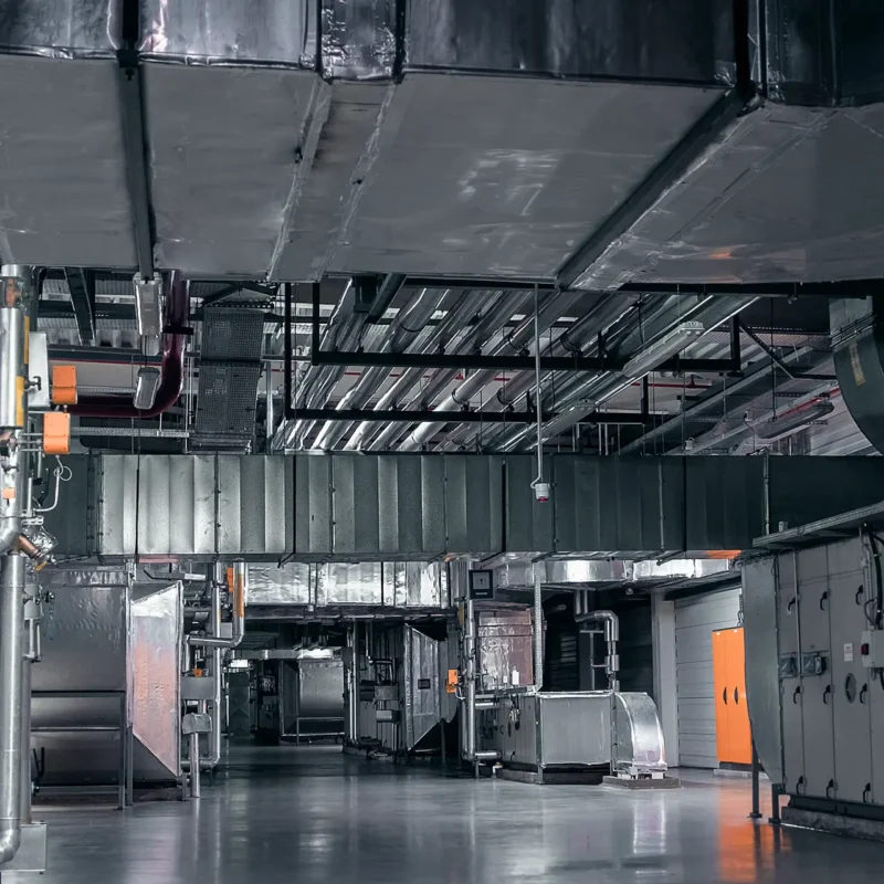Unità di trattamento aria industriale installata in grande spazio con canalizzazioni per climatizzazione di capannoni e fiere