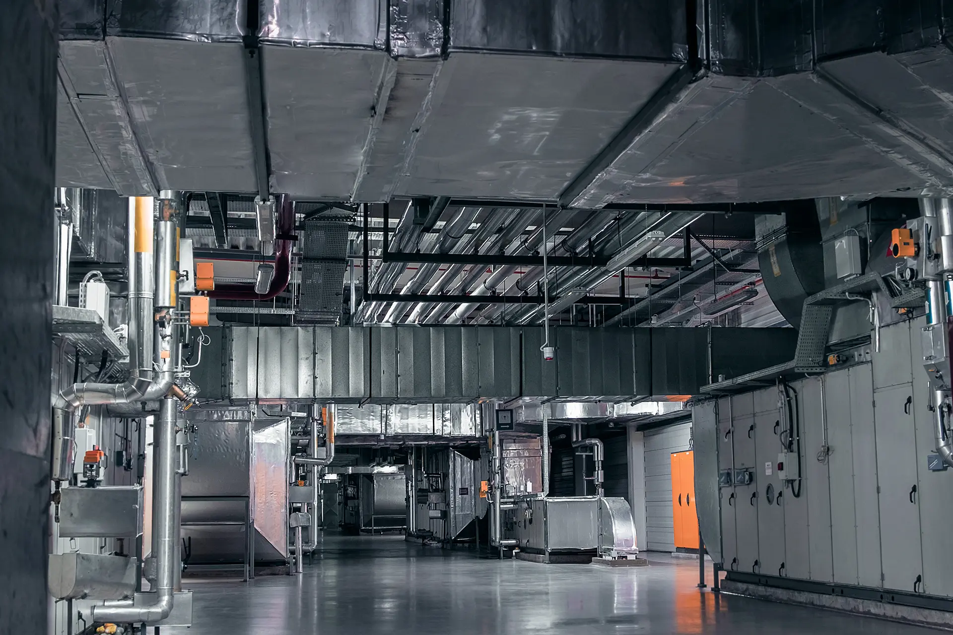Unità di trattamento aria industriale installata in grande spazio con canalizzazioni per climatizzazione di capannoni e fiere